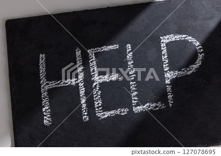 A board with the word help written on it A board with the word help written on it 127078695