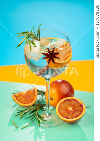 Summer cocktail with gin, tonic, blood orange, cinnamon, anise, and rosemary. 127078826