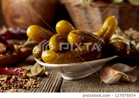Pickled cucumbers with ingredients on an old wooden table. Pickled cucumbers with ingredients on an old wooden table. 127078854