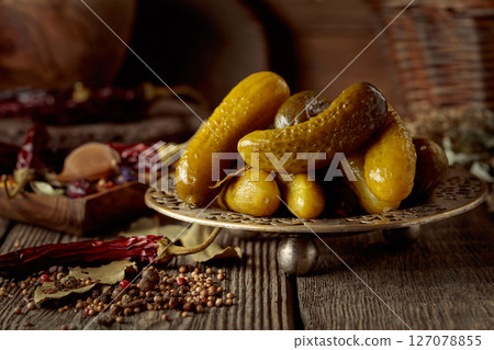 Pickled cucumbers with ingredients on an old wooden table. Pickled cucumbers with ingredients on an old wooden table. 127078855