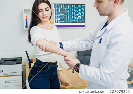 Traumatologist examining patient hands in modern hospital 127079203
