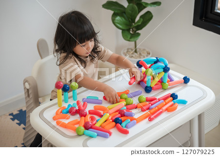 toddler girl playing colorful magnetic construction toy toddler girl playing colorful magnetic construction toy 127079225