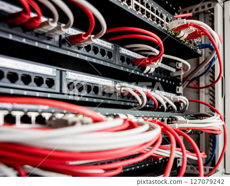 Network switch and ethernet cables in red and white colors. Data Center Network switch and ethernet cables in red and white colors. Data Center 127079242