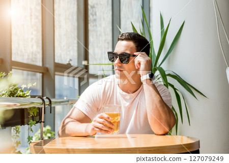 Young man in the pub. Drinking beer, eating pizza. 127079249