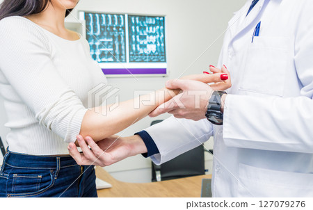 Traumatologist examining patient hands in modern hospital 127079276
