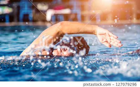 Young athletic man swimming in the swimming pool Young athletic man swimming in the swimming pool 127079296