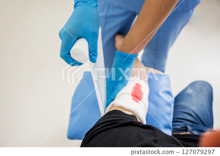Nurse dressing wound for patient's hand with deep skin cutting. Nurse dressing wound for patient's hand with deep skin cutting. 127079297