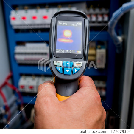 Technician use infrared thermal imaging camera to check temperature at fuse-box 127079304