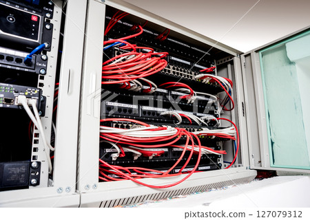 Network switch and ethernet cables in red and white colors. Data Center Network switch and ethernet cables in red and white colors. Data Center 127079312