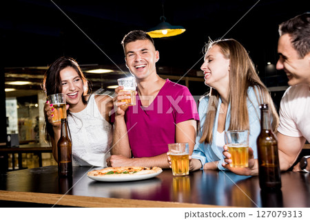 Cheerful friends in the pub. Drinking beer, wine and whisky Cheerful friends in the pub. Drinking beer, wine and whisky 127079313