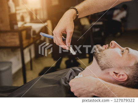 Young man with trendy haircut at barber shop. Young man with trendy haircut at barber shop. 127079322