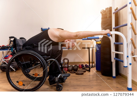 Disabled man training in the gym. Rehabilitation center Disabled man training in the gym. Rehabilitation center 127079344