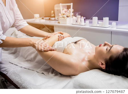 Beautiful young woman enjoying massage in spa salon. Cosmetology Beautiful young woman enjoying massage in spa salon. Cosmetology 127079487