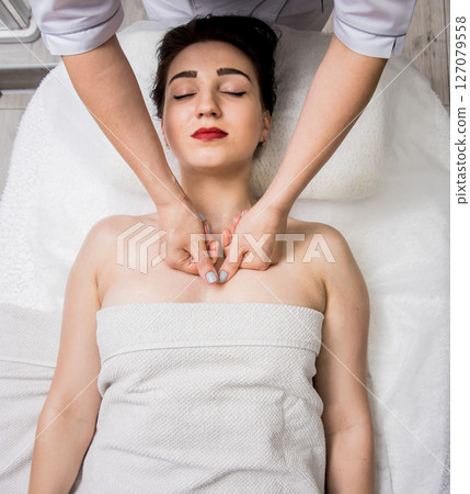 Beautiful young woman enjoying massage in spa salon. Cosmetology 127079558