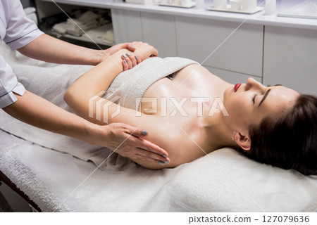 Beautiful young woman enjoying massage in spa salon. Cosmetology Beautiful young woman enjoying massage in spa salon. Cosmetology 127079636