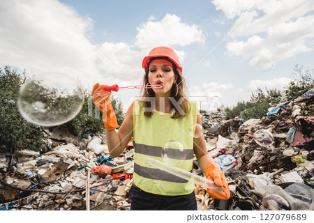 Woman volunteer with bubbles helps clean the field of plastic garbage 127079689