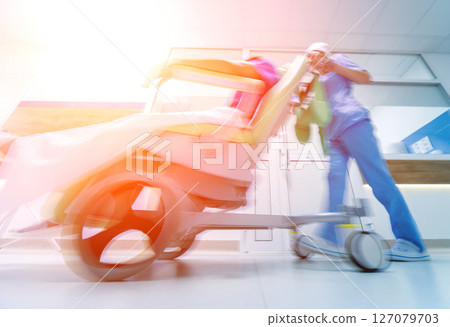 Nurse moves mobile medical chair with patient at hospital. Medical equipment. 127079703