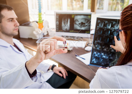 Doctors team having medical council in hospital. Spine fixation systems Doctors team having medical council in hospital. Spine fixation systems 127079722