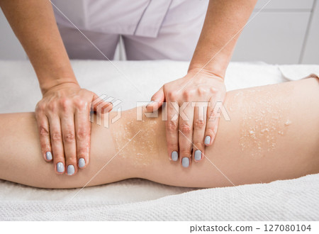 Beautiful young woman enjoying legs massage with oil in spa salon. Cosmetology Beautiful young woman enjoying legs massage with oil in spa salon. Cosmetology 127080104