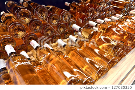 Many bottles of wine neatly arranged on a shop shelf 127080330