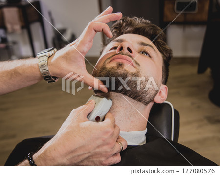 Young man with trendy haircut at barber shop.  127080576