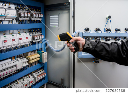 Technician use infrared thermal imaging camera to check temperature at fuse-box 127080586