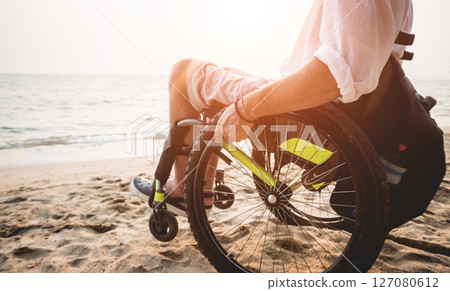 Disabled man in a wheelchair on the beach. 127080612