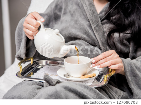 Young woman drinking herbal tea after spa procedures. Young woman drinking herbal tea after spa procedures. 127080708
