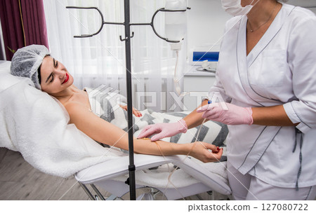 The doctor cosmetologist makes cosmetology dropper procedure. Infusion.  127080722