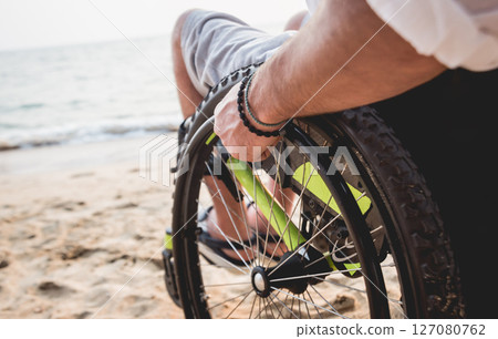 Disabled man in a wheelchair on the beach. 127080762