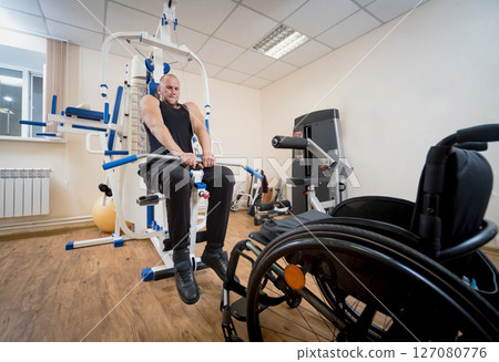 Disabled man doing strength exercises separate from the wheelchair. Disabled man doing strength exercises separate from the wheelchair. 127080776