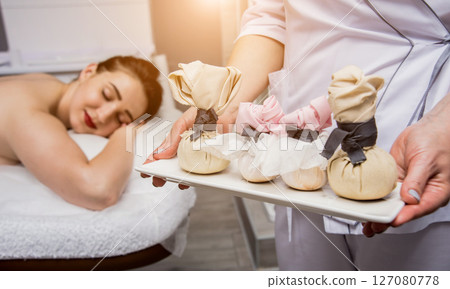 Beautiful young woman enjoying massage in spa salon. Cosmetology 127080778