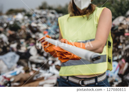 Woman volunteer helps clean the field of plastic garbage. Woman volunteer helps clean the field of plastic garbage. 127080811