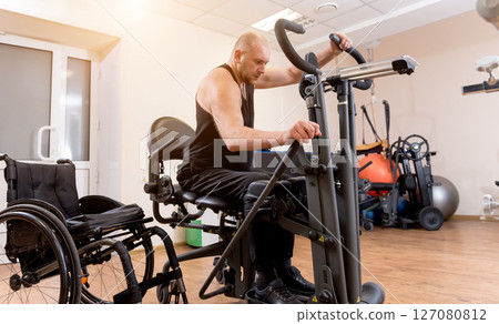 Disabled man training in the gym. Rehabilitation center 127080812