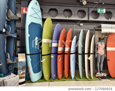 A collection of various surfboards are neatly lined up in a store A collection of various surfboards are neatly lined up in a store 127080928