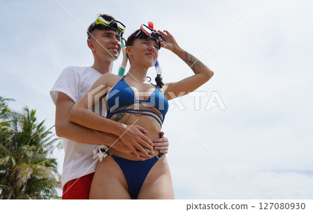 A man and woman wear goggles and snorkels before diving A man and woman wear goggles and snorkels before diving 127080930