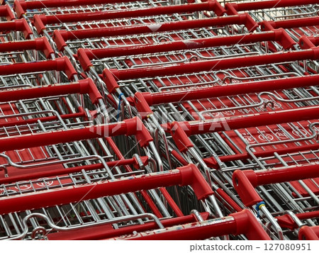 A row of shopping carts is neatly lined up in a straight row A row of shopping carts is neatly lined up in a straight row 127080951