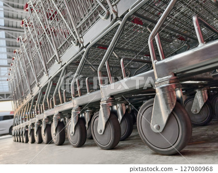 A row of shopping carts is neatly lined up in a straight row 127080968