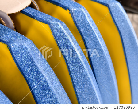 This image features a closeup view of a blue and yellow striped plastic. 127080989