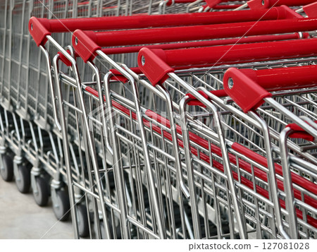 A row of shopping carts is neatly lined up in a straight row A row of shopping carts is neatly lined up in a straight row 127081028