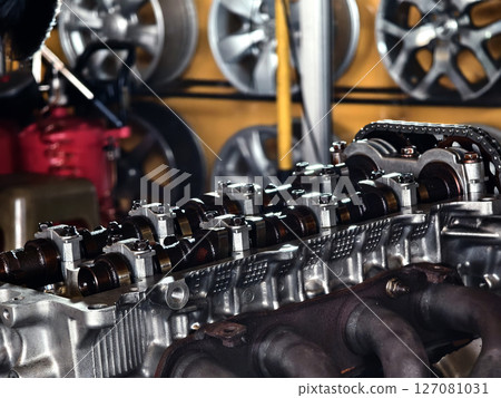 A car engine is being worked on inside a garage workshop A car engine is being worked on inside a garage workshop 127081031