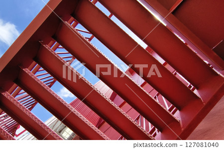 A set of stairs ascending a large red wall A set of stairs ascending a large red wall 127081040
