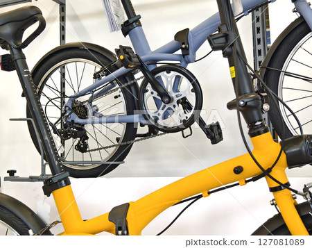 A variety of bicycles are hanging on a rack inside a sport store 127081089