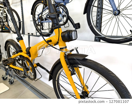 A variety of bicycles are hanging on a rack inside a sport store A variety of bicycles are hanging on a rack inside a sport store 127081107