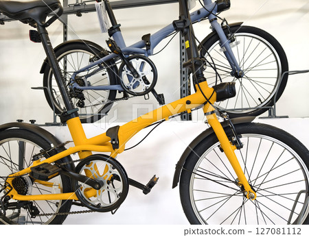 A variety of bicycles are hanging on a rack inside a sport store A variety of bicycles are hanging on a rack inside a sport store 127081112