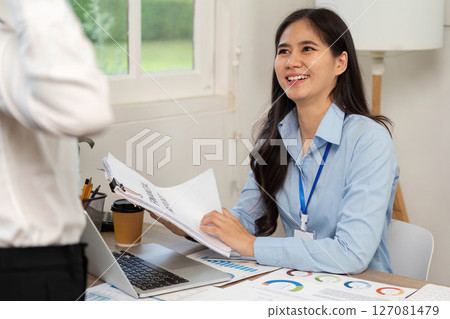 Professional Business Meeting. A smiling woman engaging in a discussion at a modern office. 127081479