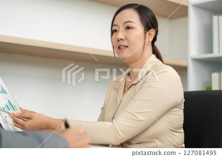Professional Discussion. Businesswoman presenting financial data in a meeting. Professional Discussion. Businesswoman presenting financial data in a meeting. 127081495