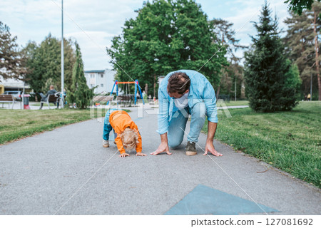 Father lining up to have a running race with his little son. 127081692