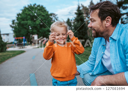 Father playing with toddler son outdoors in park Father playing with toddler son outdoors in park 127081694
