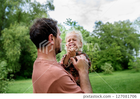 Loving father helping to injured crying toddler boy. 127081706
